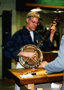 Demonstrating a handcrafted banjo at a woodworking fair